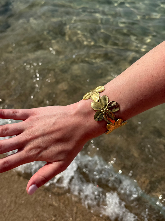bracelet doré fleurs porté sur la plage