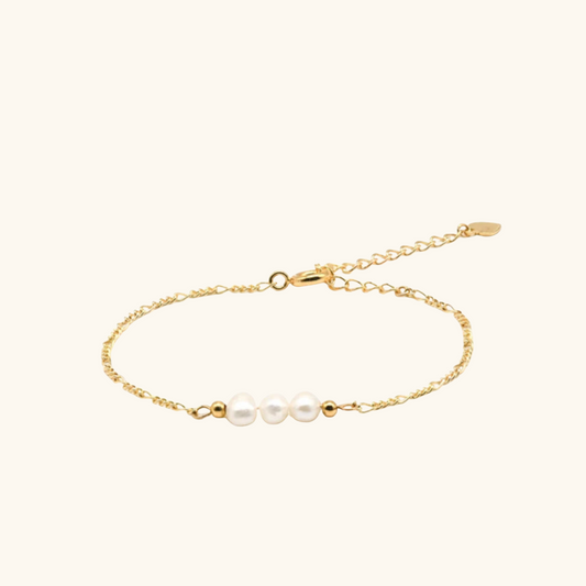 bracelet doré avec trois perles blanches