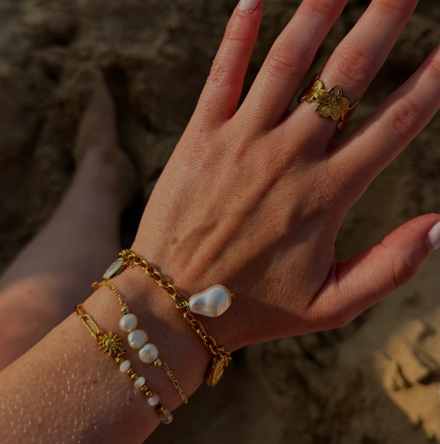 selection de bijoux dorés portés sur la plage